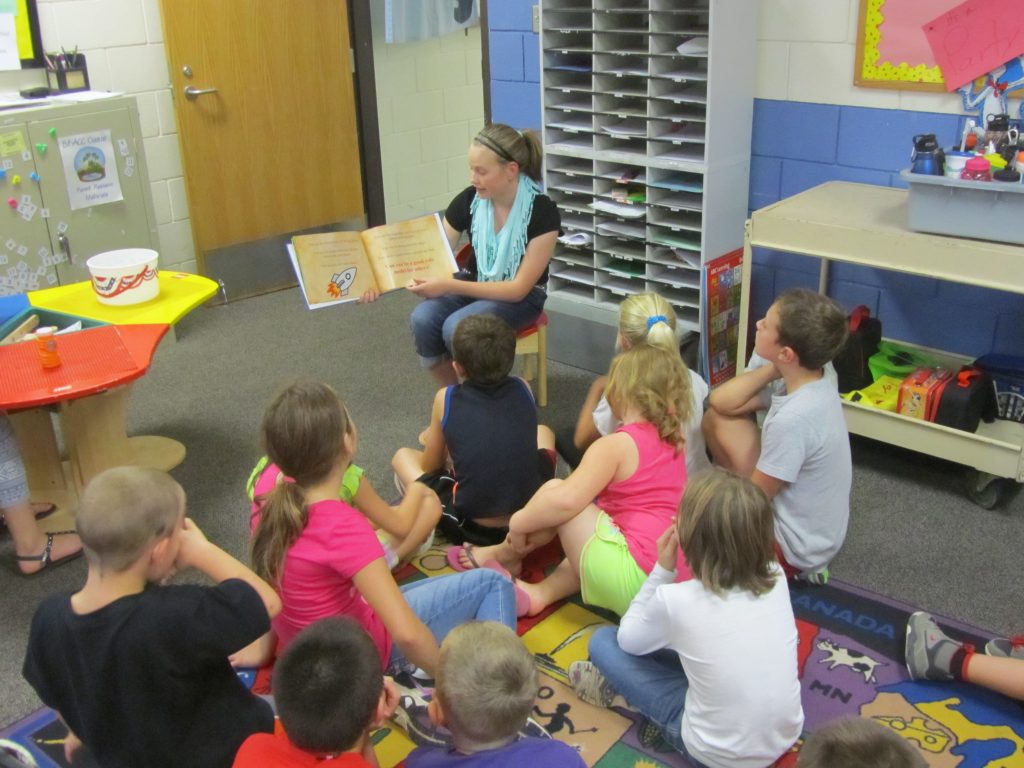 Girl Reading Book to Class