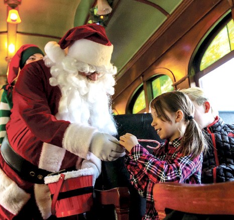 Santa visiting with a child aboard the 1880 Train Holiday Express.